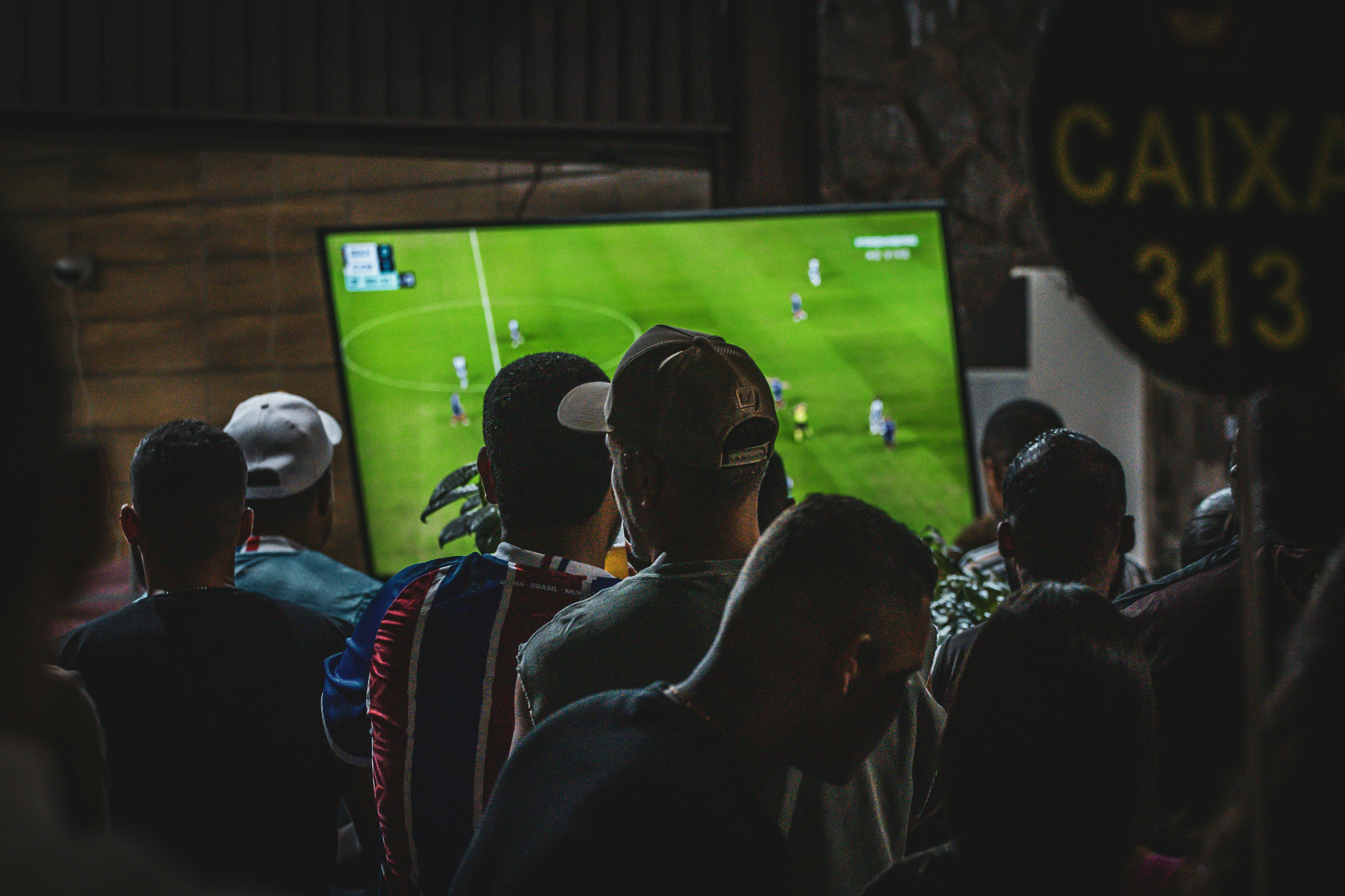 Torcedores assistindo a uma partida de futebol na TV
