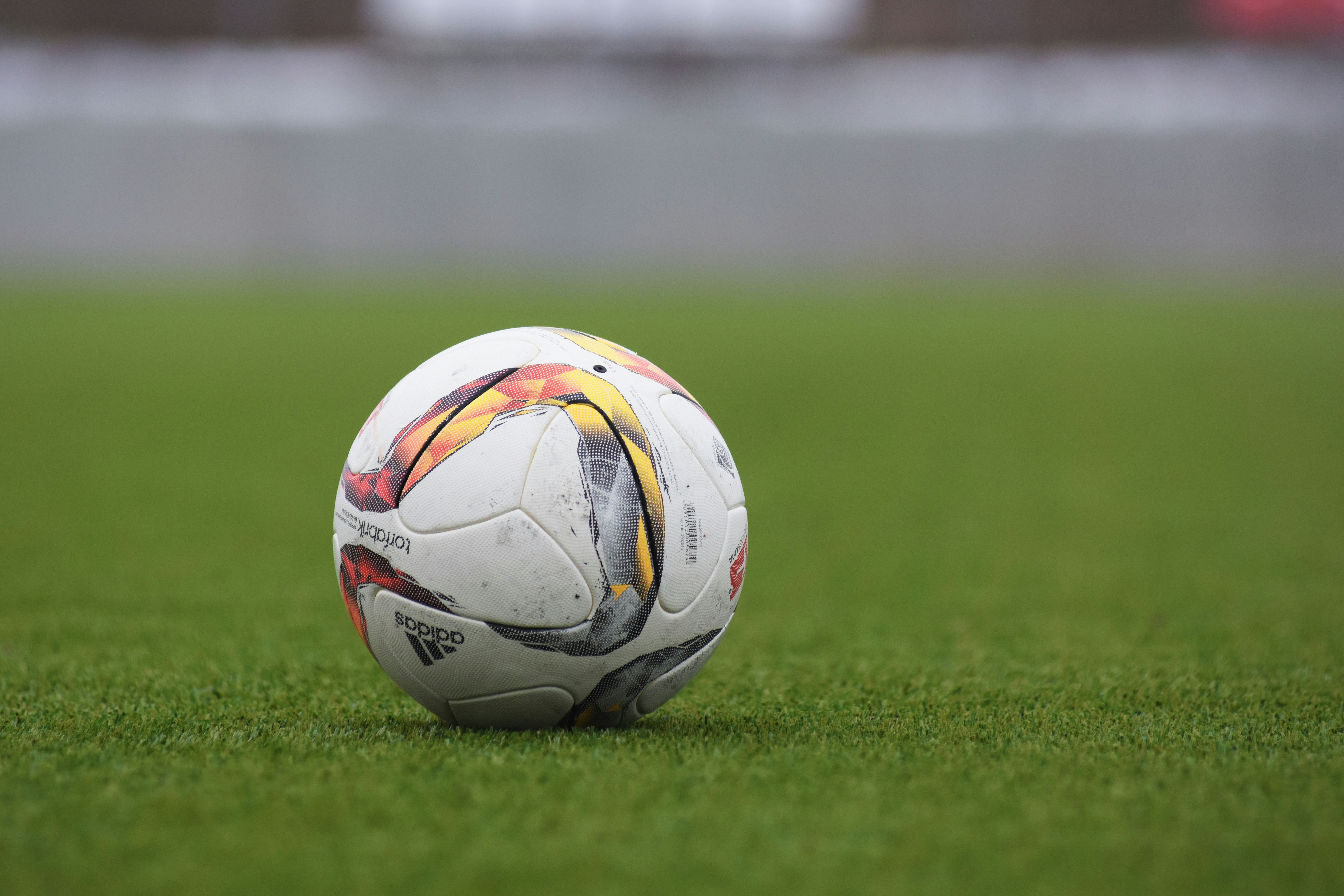Bola de futebol em close sobre o gramado